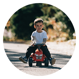 enfant sur un jouet roulant rouge