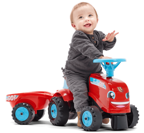 petit enfant souriant sur un tracteur Falk Toys