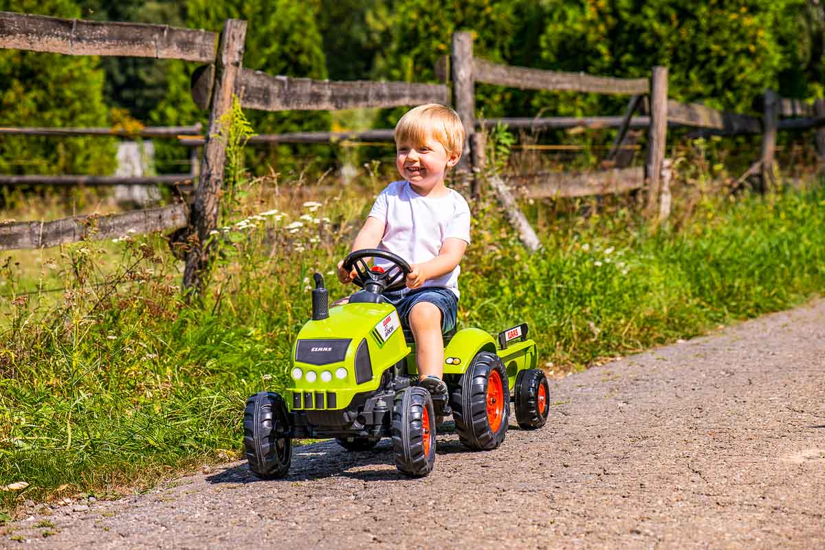 Enfant jouant avec Tracteur à pédales Claas Falk Toys 2041C en plein air